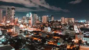 A vibrant city skyline at night with tall buildings and bright lights.