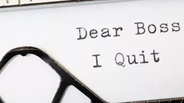 Typewriter with a typed note saying 'Dear Boss, I Quit.'