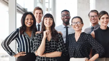 Group of professionals smiling in an office.