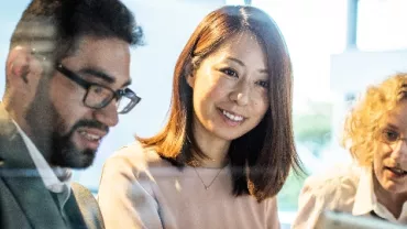 Two women and a man in an office setting